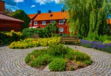 Rött trähus med blomsterprakt